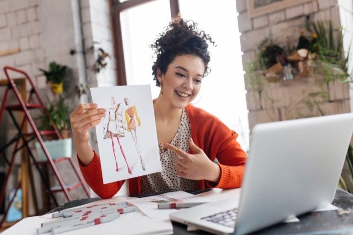 Boutique owner reviewing fashion designs while connected to ClothME